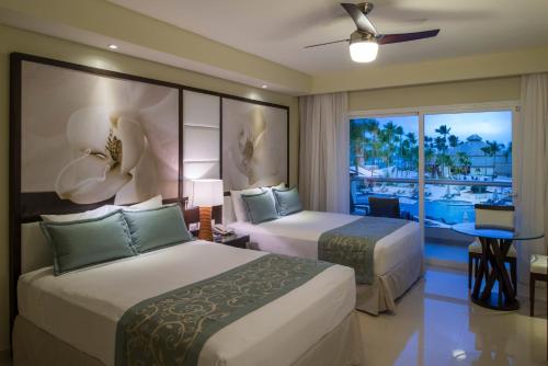 プンタ・カナにあるRoyalton Punta Cana, An Autograph Collection All-Inclusive Resort & Casinoのベッド2台とバルコニーが備わるホテルルームです。