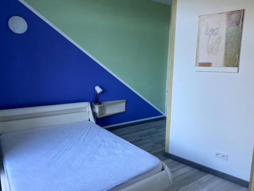 a bedroom with a blue wall and a bed at Domaine des Anges in Amélie-les-Bains-Palalda