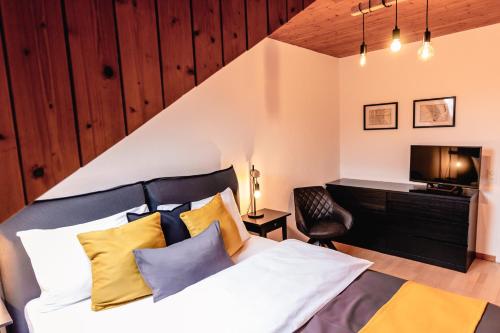 a bedroom with a bed with yellow and blue pillows at Armotti Apartments Lorraine in Bern