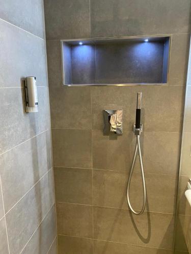a shower with a hose in a bathroom at Apartment BERGliebe - schnuckelig, ruhige und zentrale Lage in Schliersee