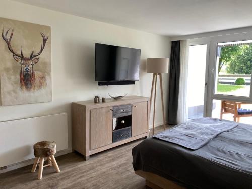 a bedroom with a bed and a flat screen tv at Apartment BERGliebe - schnuckelig, ruhige und zentrale Lage in Schliersee