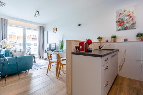 a kitchen and a living room with a table at Symphony Baltica Towers Apartamenty in Gdańsk
