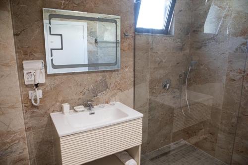 a bathroom with a sink and a shower at Hotel Qeparo in Qeparo