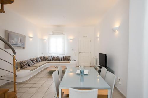 een woonkamer met een tafel en een bank bij Villa Nireas in Platis Yialos Mykonos