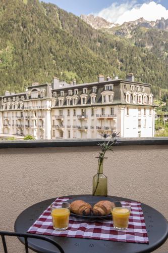 a table with a plate of bread and two glasses of orange juice at Pointe Isabelle in Chamonix-Mont-Blanc