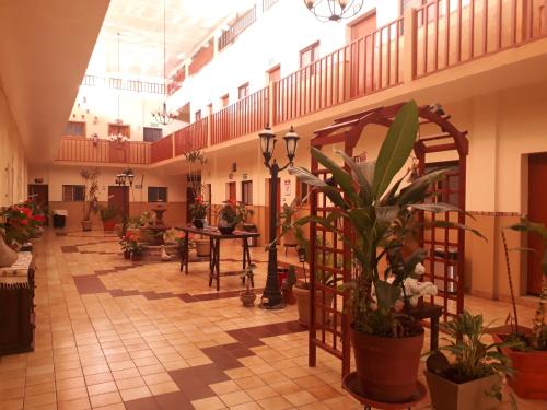 un gran vestíbulo con plantas, mesas y escaleras en Hotel Cervantino, en Tapachula