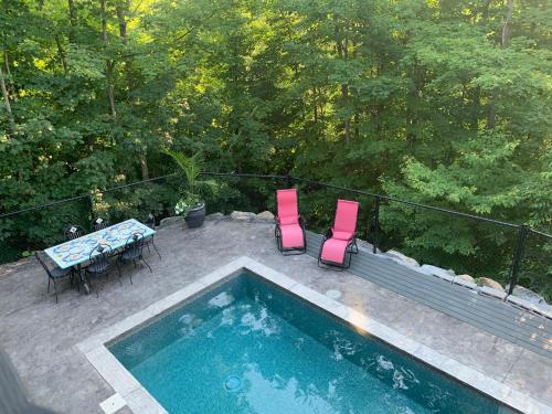 an overhead view of a swimming pool with chairs and a table at La Bohème - Bed & Breakfast in Bromont
