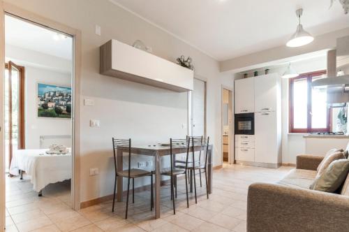 una cucina e un soggiorno con tavolo e sedie di Rhomy Apartment a Sperlonga