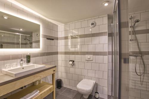 a bathroom with a sink and a toilet and a shower at Pointe Isabelle in Chamonix-Mont-Blanc
