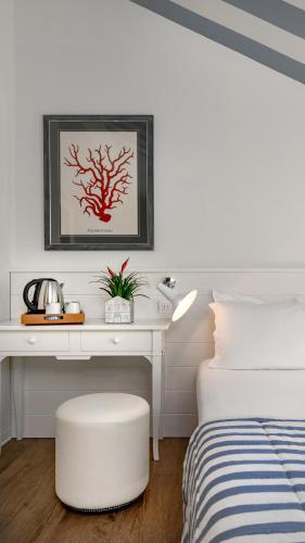 a bedroom with a white desk with a bed and a white chair at Hotel Panorama in Cattolica