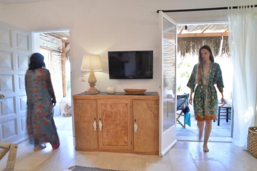 a woman walking through a living room with a mirror at Aloe Mare Suites in Liaropá