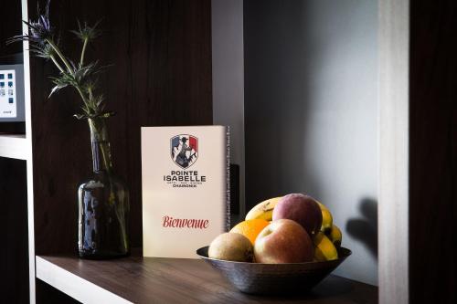 a bowl of fruit on a shelf next to a book at Pointe Isabelle in Chamonix-Mont-Blanc