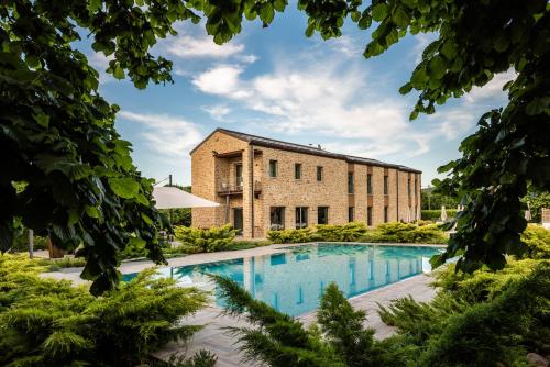 een extern uitzicht op een bakstenen gebouw met een zwembad bij Villa Gelso in Vesime
