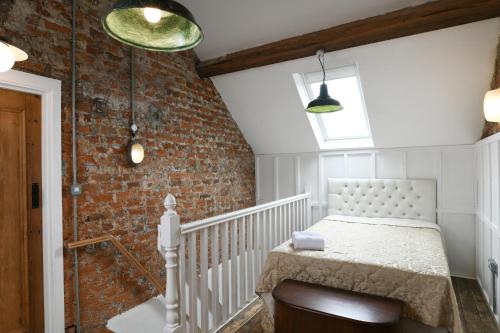 a bedroom with a bed and a brick wall at The Milk House in Tobermore
