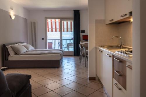 a room with a bed and a kitchen with a table at Residence Villa al Lido in Brenzone sul Garda
