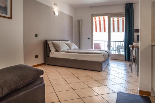 a bedroom with a bed and a tiled floor at Residence Villa al Lido in Brenzone sul Garda