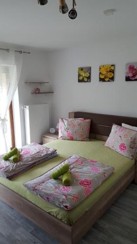 two beds in a bedroom with green sheets and pillows at Penzión Zunama in Bardejovské Kúpele