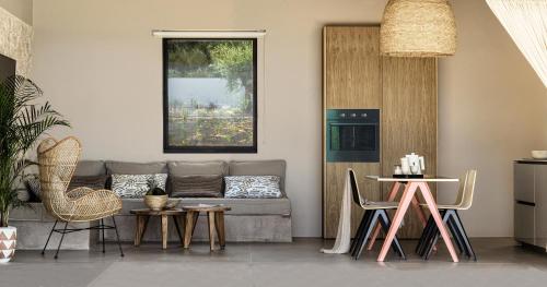 a living room with a couch and a table and chairs at Mimi and Coco Villas Corfu in Paramonas