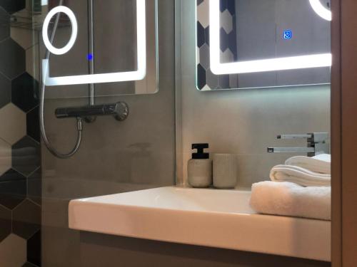 een badkamer met een wastafel, een spiegel en handdoeken bij GoConcept Studio in Iaşi