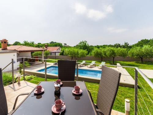 a table and chairs with a view of a pool at Villa Viktoria poll&garden view in Kaštelir