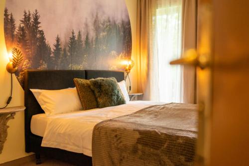 a bedroom with a bed with a large painting on the wall at Hotel am Bach in Hinterzarten
