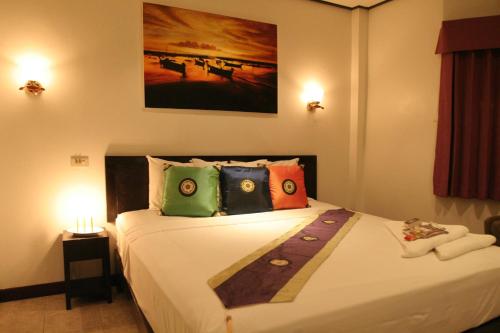 a bedroom with a large bed with colorful pillows at Angus O'Tool's Guesthouse in Karon Beach