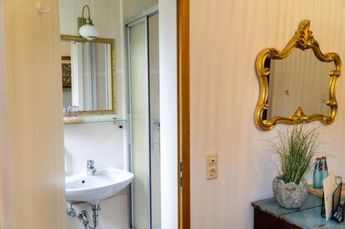 a bathroom with a sink and a mirror on the wall at Hotel am Bach in Hinterzarten