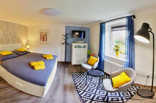 een slaapkamer met een bed en 2 stoelen en een raam bij Penzion Mini in Liberec