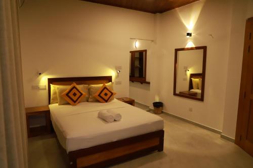 a bedroom with a large bed and a mirror at House On The Bend in Hiriketiya