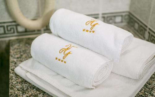 a pile of towels on a counter in a bathroom at Hotel Gottwald in Tata