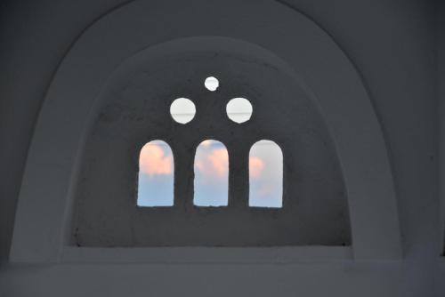 an archway with three windows in a building at Aloe Mare Suites in Liaropá