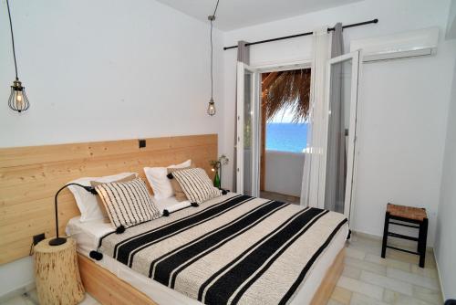 a bedroom with a bed with a view of the ocean at Aloe Mare Suites in Liaropá
