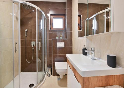 a bathroom with a shower and a sink and a toilet at Apartman Libra Zlatibor in Zlatibor