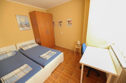 ein kleines Schlafzimmer mit 2 Betten und einem Tisch in der Unterkunft Topart in Koper