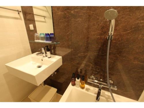 ein Bad mit einer Dusche, einem Waschbecken und einer Dusche in der Unterkunft Hotel Meldia Shijo Kawaramachi - Vacation STAY 86749 in Kyoto
