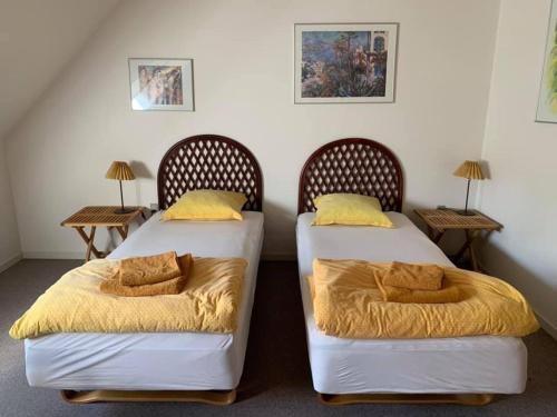 two beds in a room with two side tables at Dortes Bed & Breakfast in Lintrup