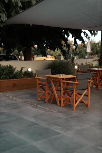 a wooden table and chairs sitting under an umbrella at Vivari Acta in Vivari