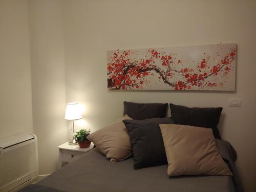 a bed in a bedroom with a painting on the wall at TINY ROOM in Sassari