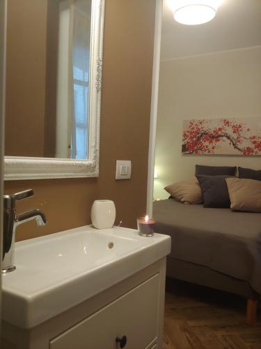 a bathroom with a sink and a mirror and a bed at TINY ROOM in Sassari