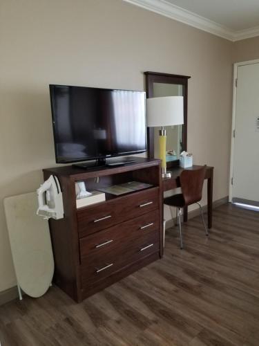 a hotel room with a television and a desk with a chair at Super 8 by Wyndham Los Angeles-Culver City Area in Los Angeles