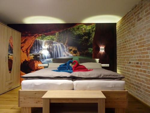 1 dormitorio con 2 camas y un mural de cascada en la pared en Pensionszimmer Ziaglhidde, en Kiebingen