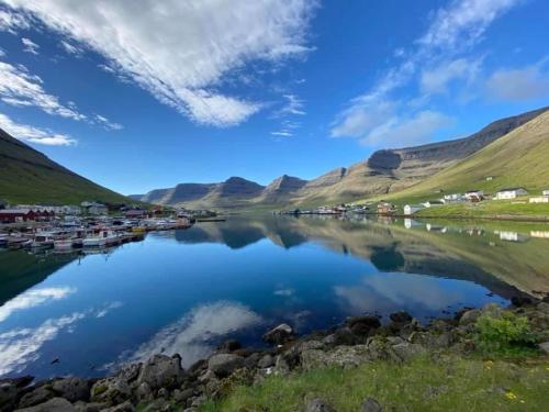 a view of a lake with houses and mountains at Lokk-Inn Apartments in Norðdepil