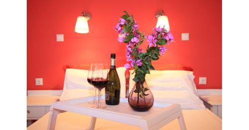 a table with two bottles of wine and a vase of flowers at Athina Apartments in Stoupa