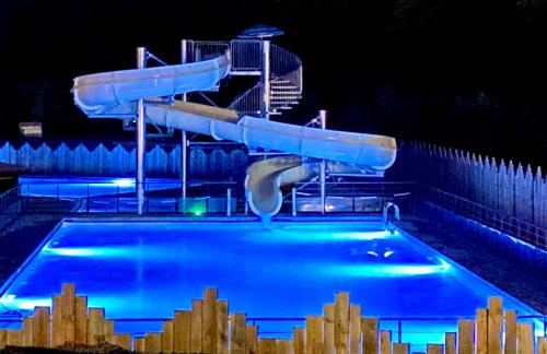 a swimming pool at night with a water slide at Camping Le Sagone in Sagone