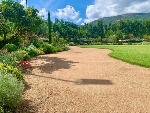 a dirt road in a garden with grass and trees at Camping Le Sagone in Sagone