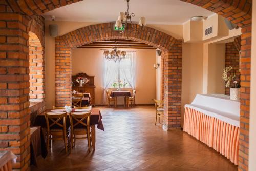 a dining room with a brick wall and a table at Hotel Przedzamcze in Działdowo