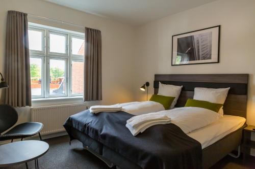 Un dormitorio con una cama grande y una ventana en Ansager Hotel og Hytteby en Ansager