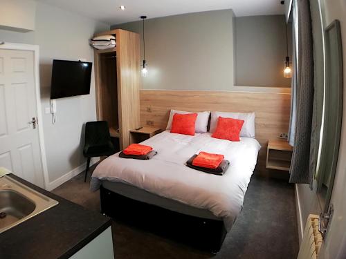 um quarto com uma cama com duas almofadas vermelhas em City Space em Doncaster