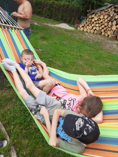 a group of children laying on a hammock at Pod akacjami in Baligród