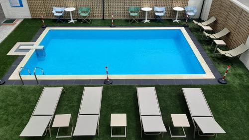 uma vista superior para uma piscina com espreguiçadeiras e mesas em Saint George Hotel em Asprovalta